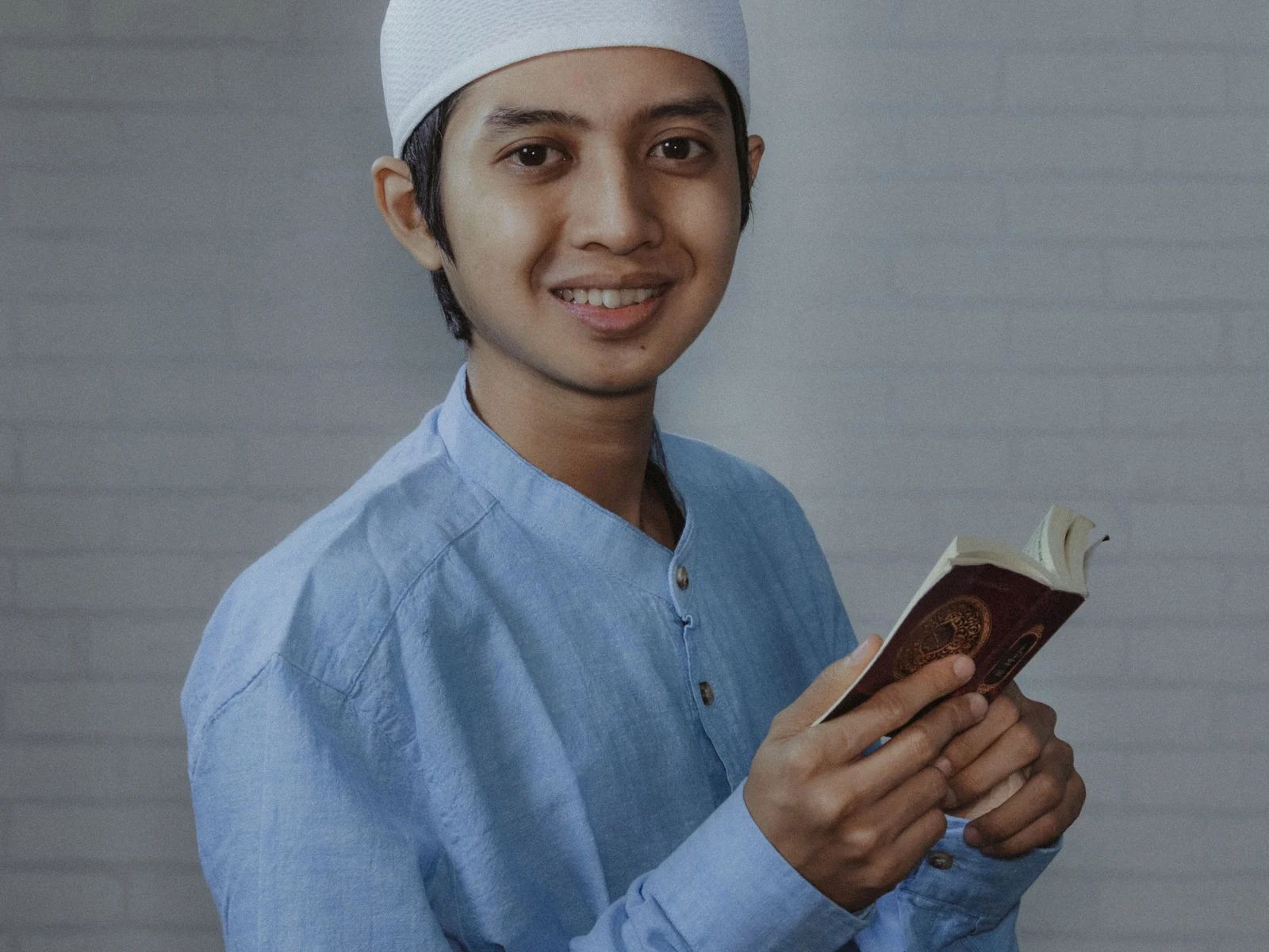 Smiling young man holding the Quran