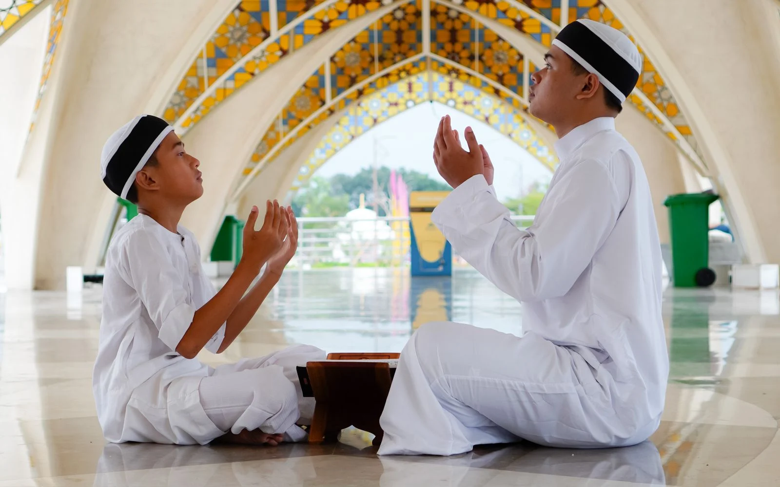 Father and son making dua together in a mosque