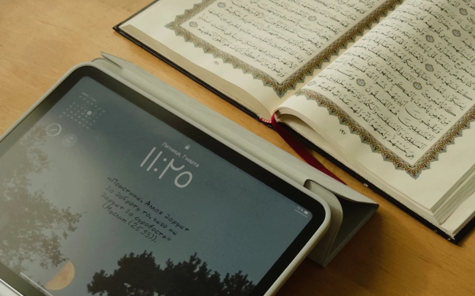 Open Quran beside a tablet for studying Tafseer and translation