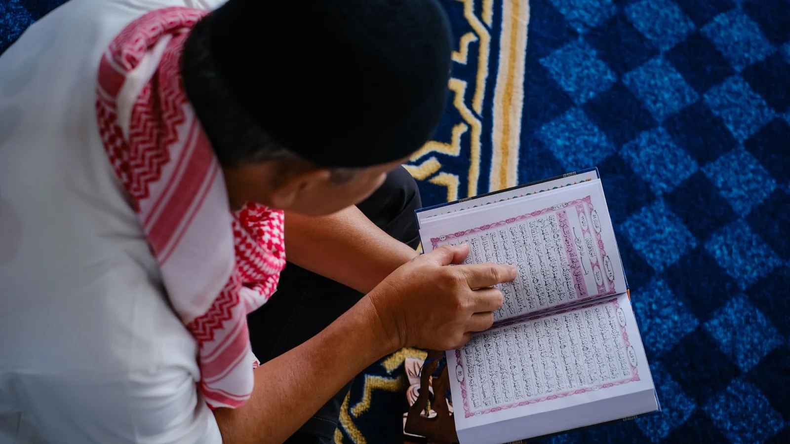 Adult man revising the Quran on a rehal for Hifz