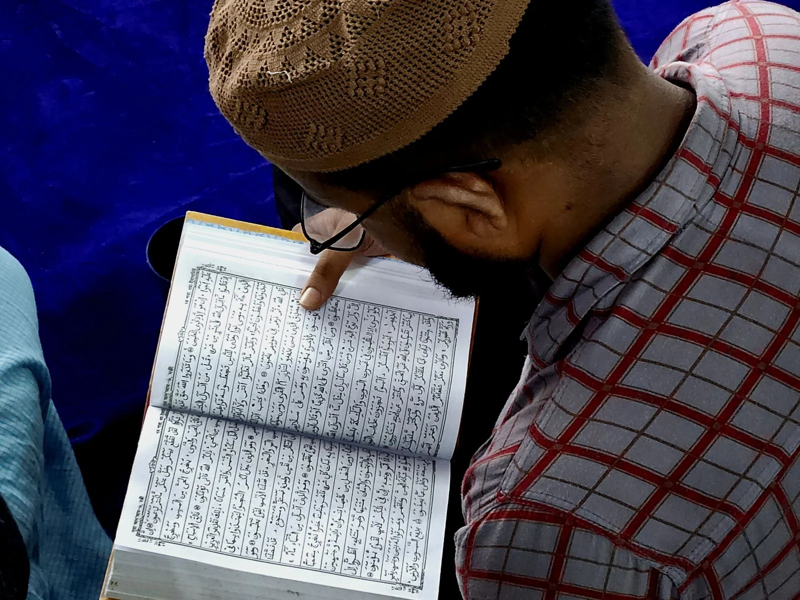Adult man memorizing the Quran in a mosque