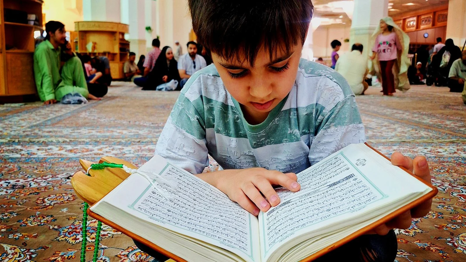 Young boy memorizing the Quran in a mosque