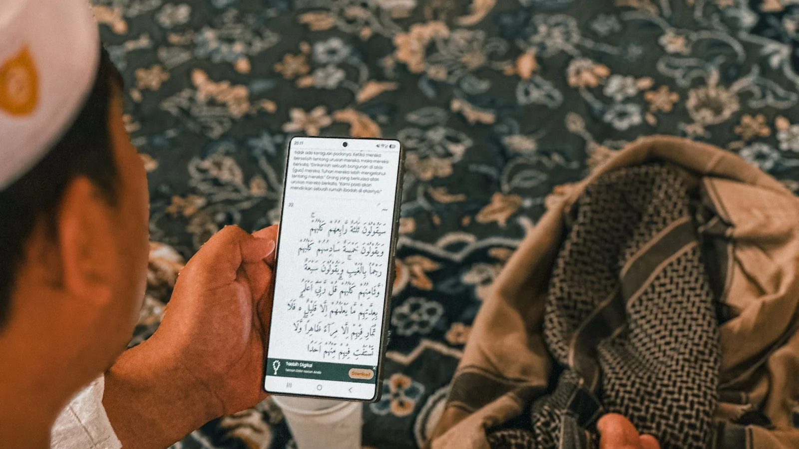 Man reciting the Quran from his phone during an online Ijazah lesson