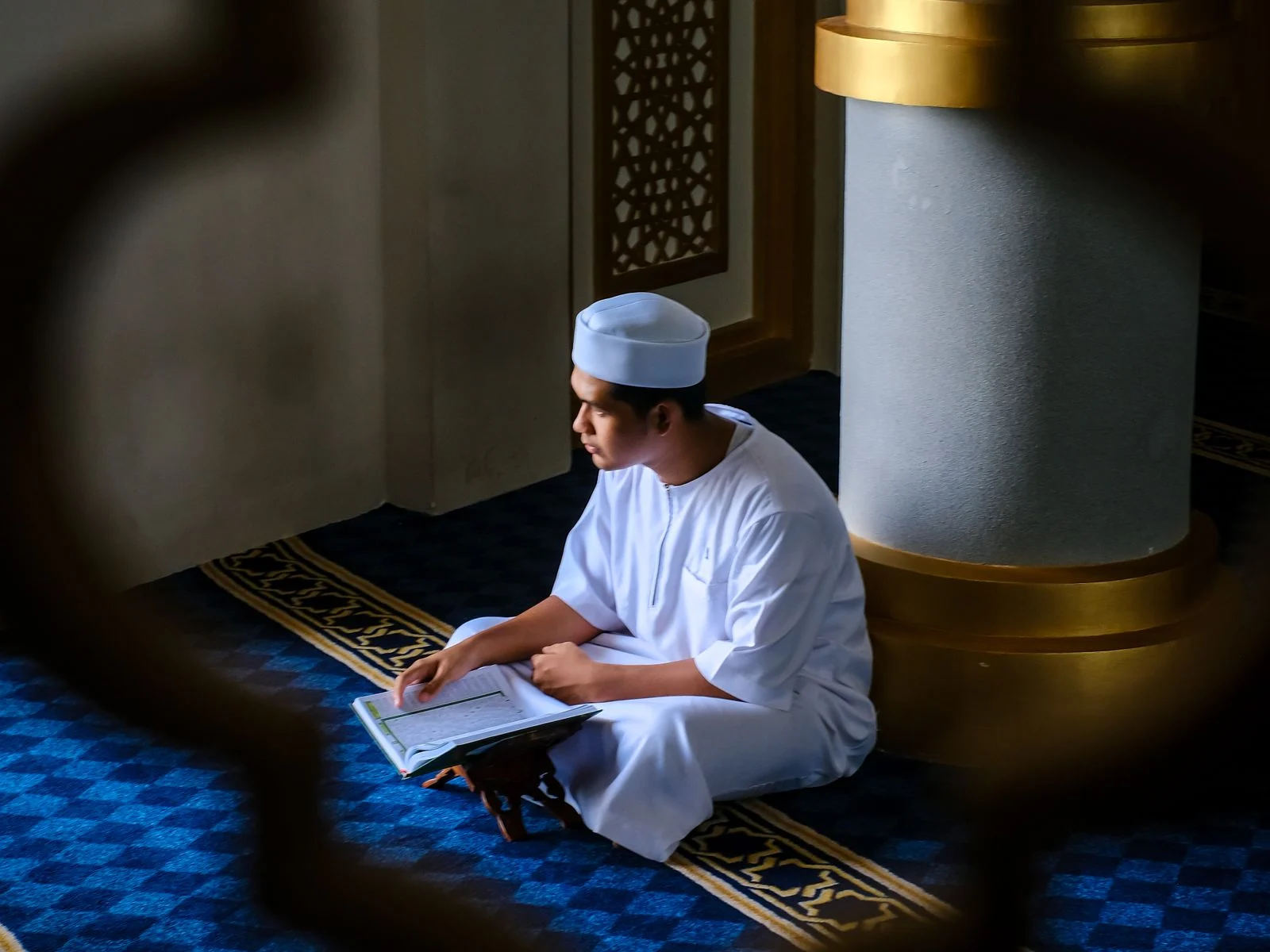 Young man calmly reading the Quran in his first lesson