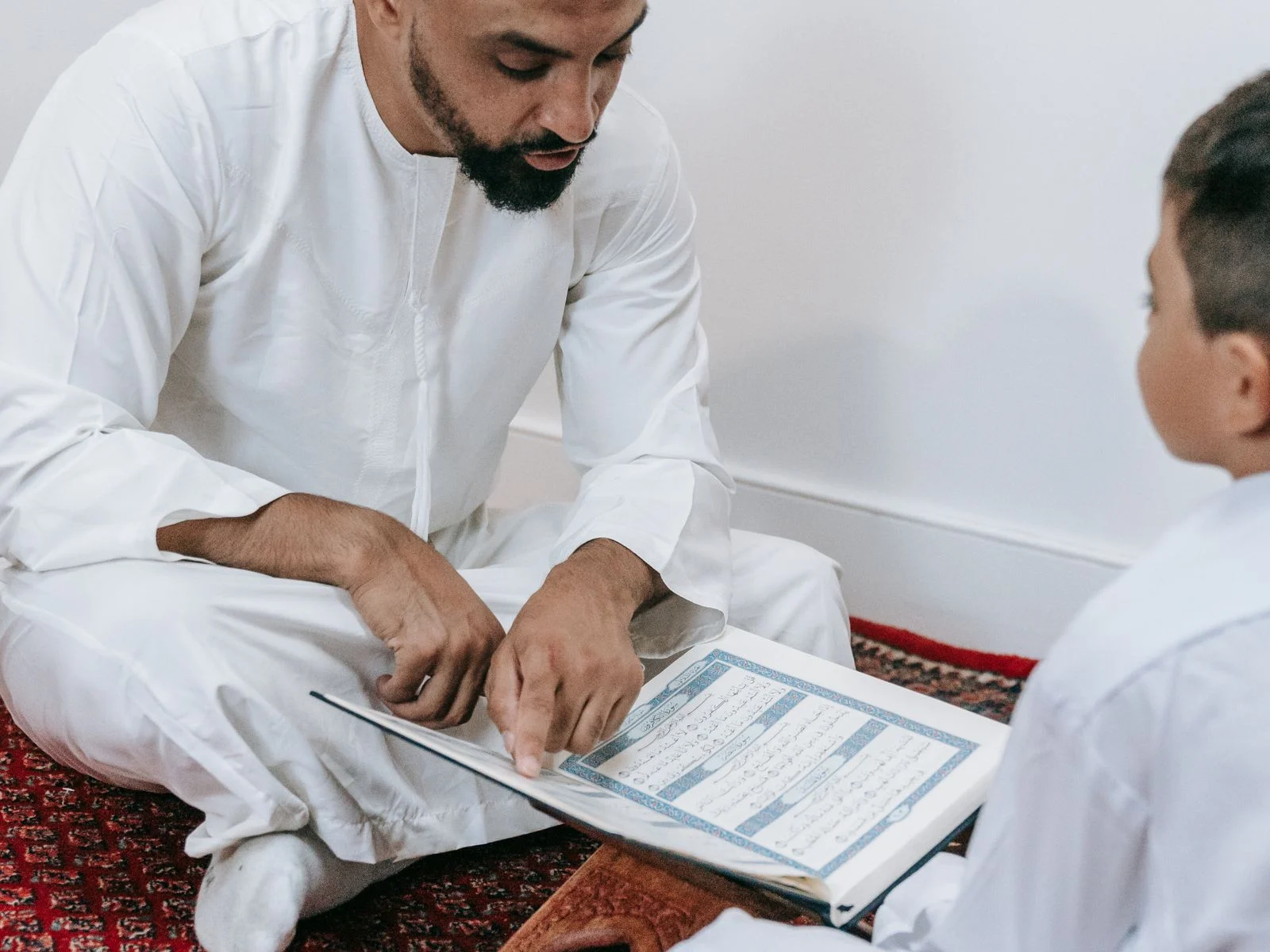 Father and son learning to read the Quran together at home