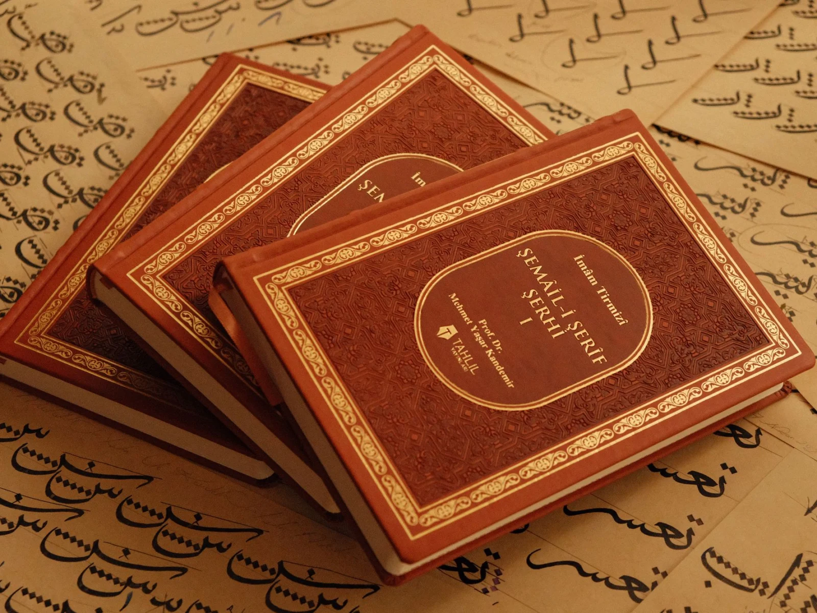 Islamic books resting on handwritten Arabic sheets for studying Quranic Arabic