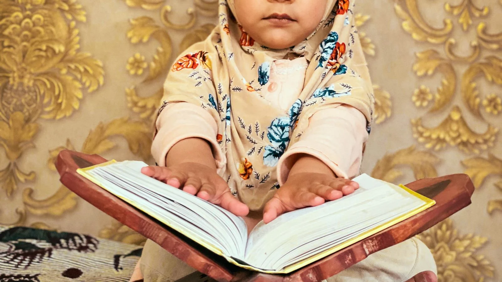 Little girl in hijab reading the Quran in her first lesson