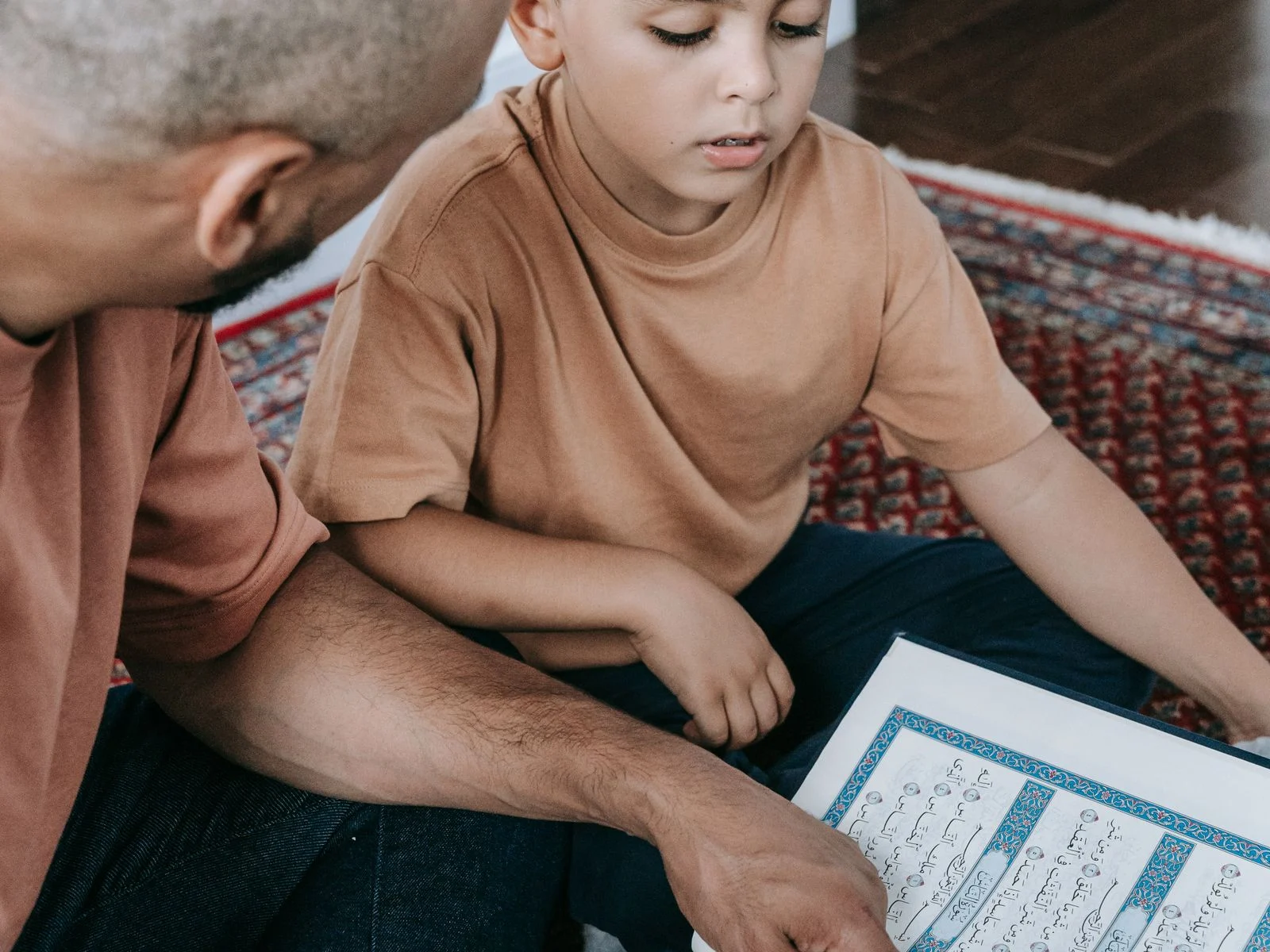 Father teaching his son the meaning of a short surah