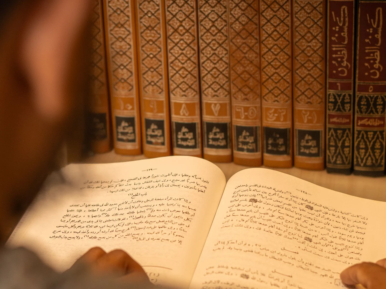 Student studying classical Tafseer books in a library