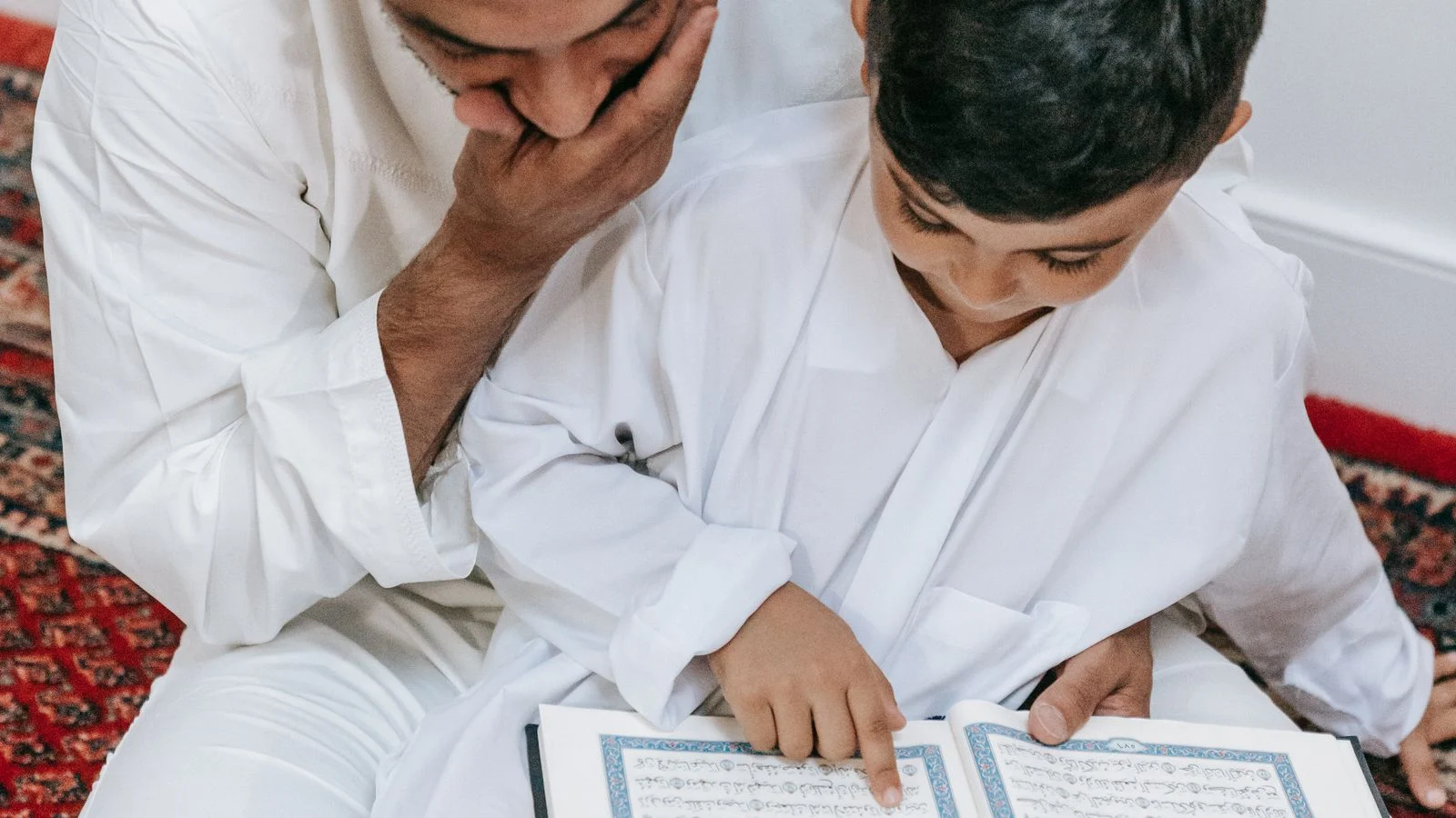 Father and son reading the Quran together